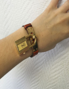 HERMES Kelly watch with ora,ge crocodile bracelet and gilded hardware