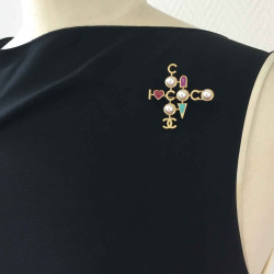 Broche CHANEL "COCO" en métal doré, perles nacrées 