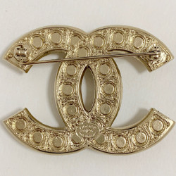 CHANEL CC brooch in gilded metal and pearls